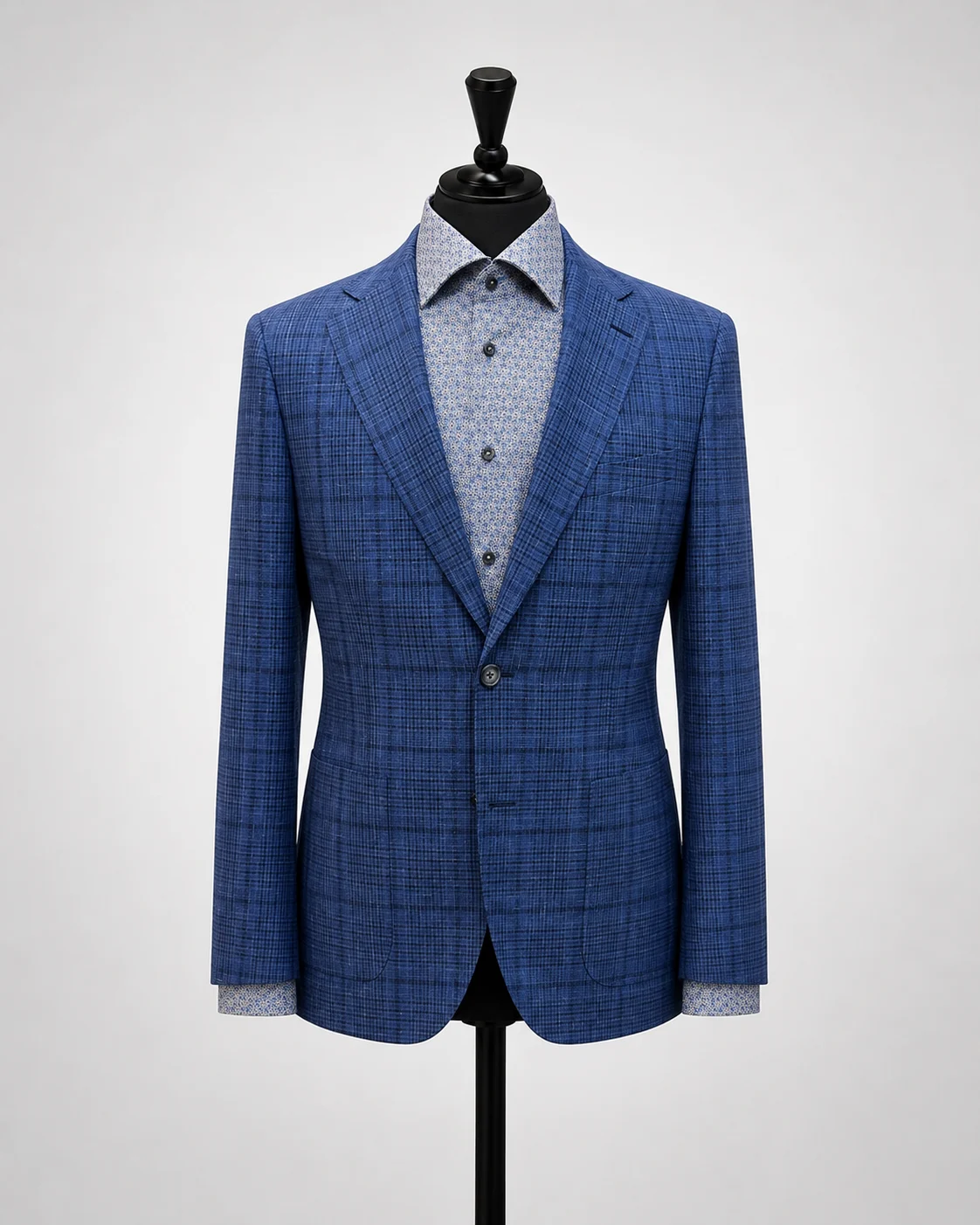 Blue plaid sport coat displayed on black mannequin with patterned shirt