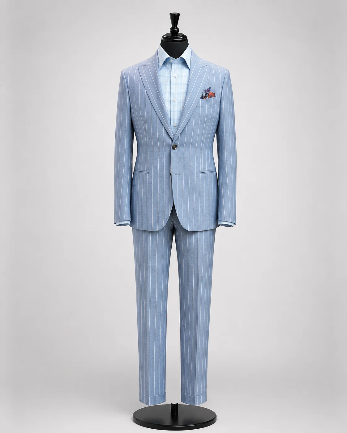 Light blue pinstripe suit displayed on a black mannequin with matching trousers, light blue shirt, and patterned pocket square.