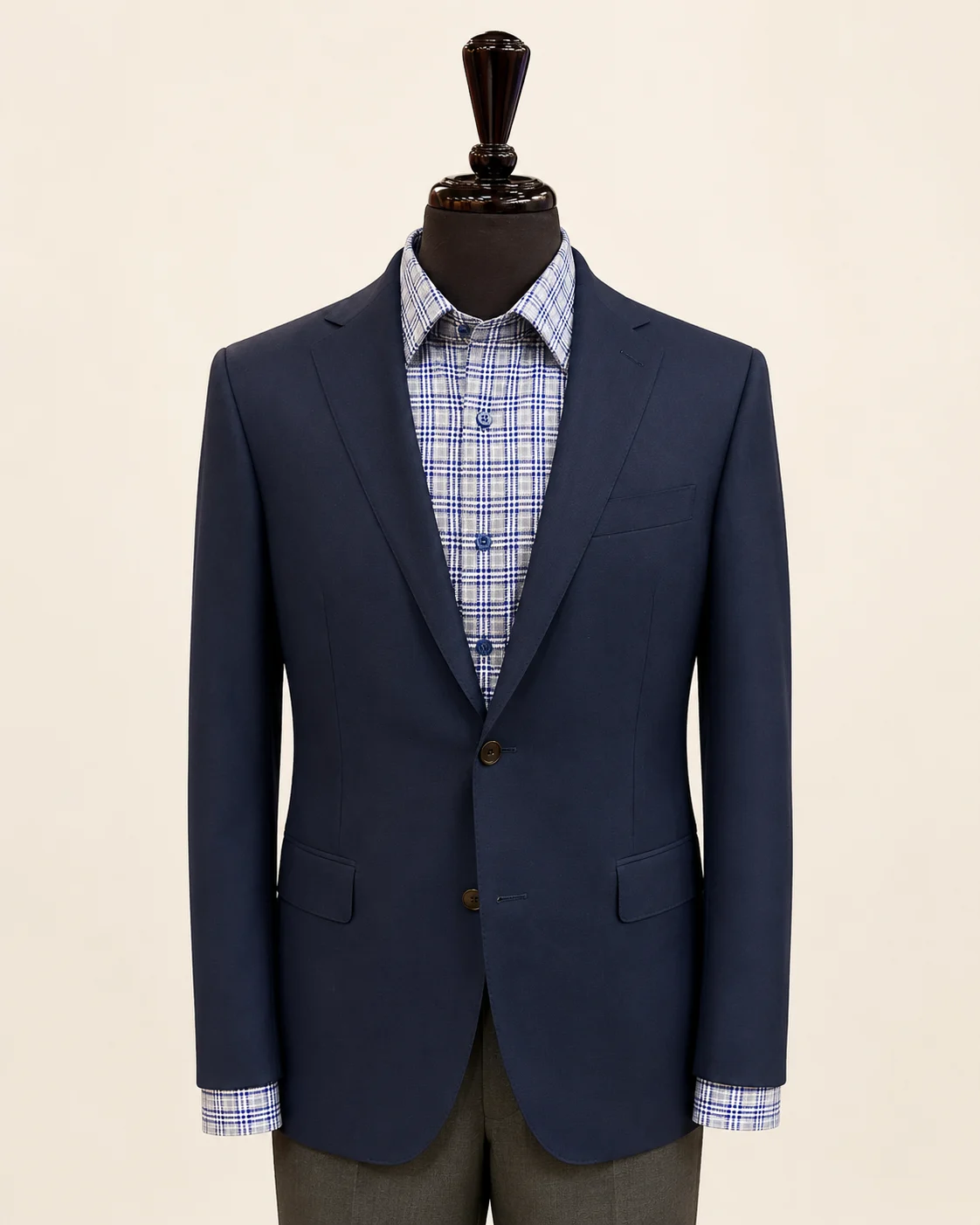Navy suit jacket displayed on a black mannequin with blue patterned shirt.