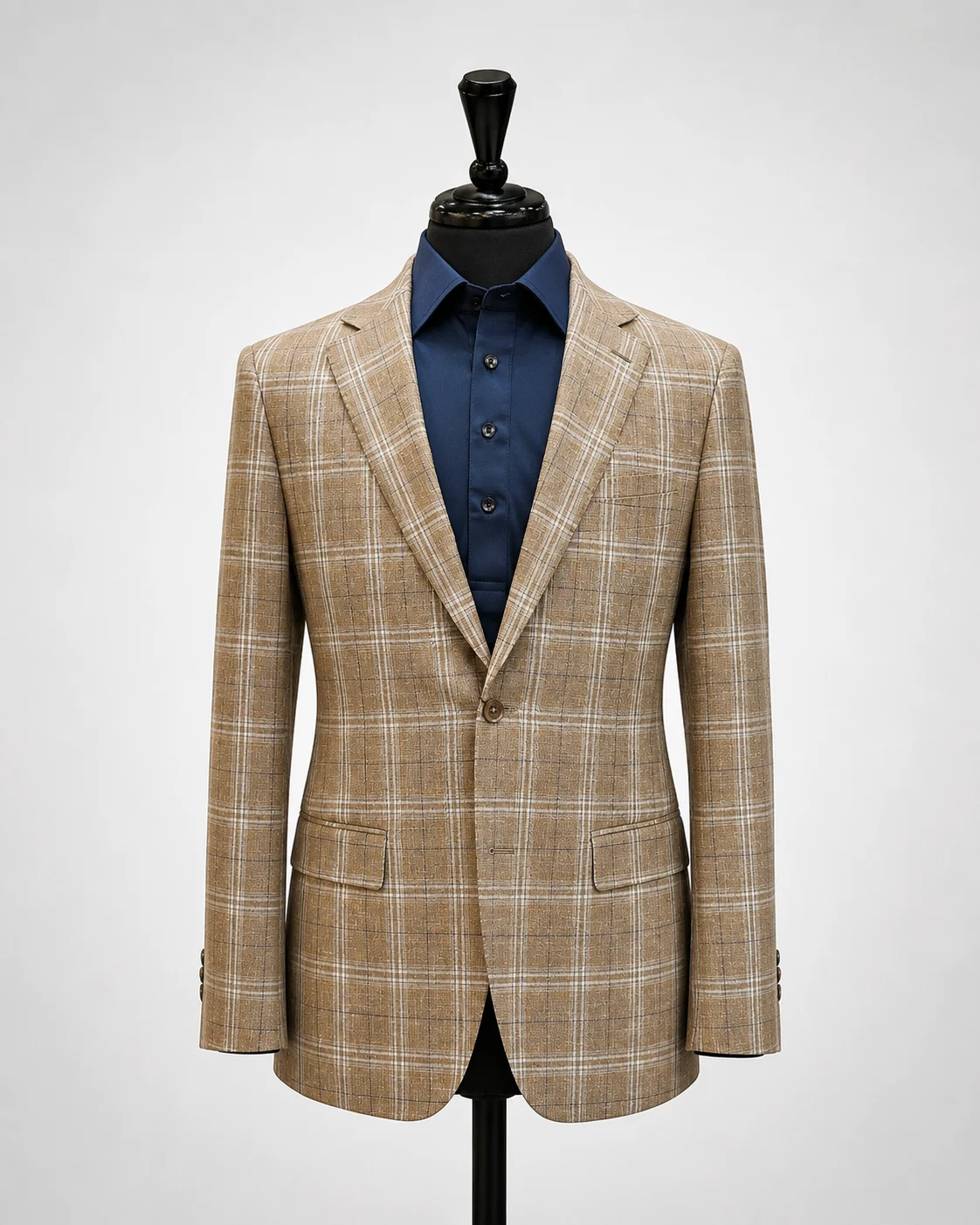 Tan plaid sport coat displayed on black mannequin with navy dress shirt